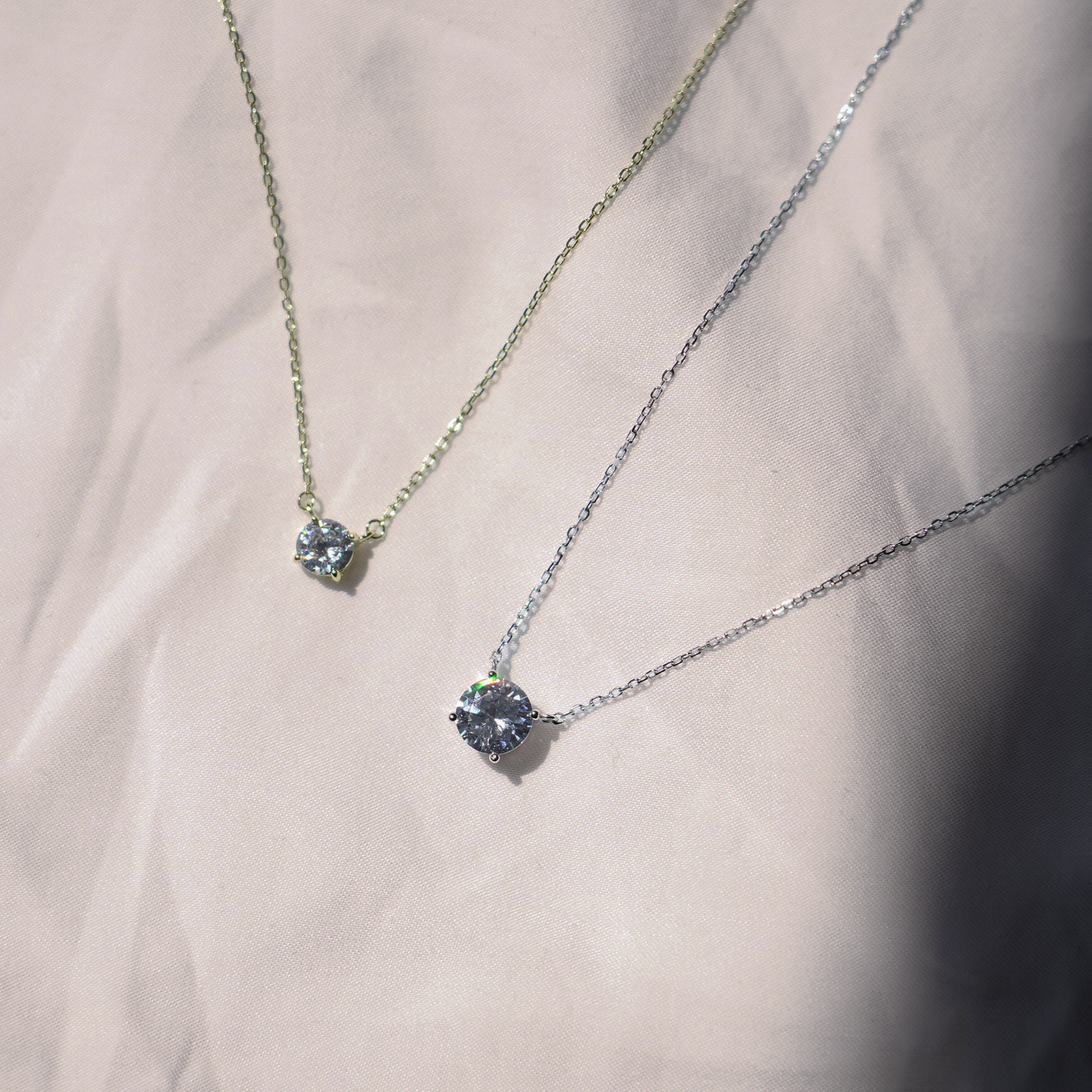 This necklace features a sparkling cubic zirconia set in a classic solitaire design. The pendant hangs on a delicate chain, available in gold vermeil or sterling silver. It closes with a secure spring ring clasp. The elegant design combines the warmth of gold and the shine of silver.