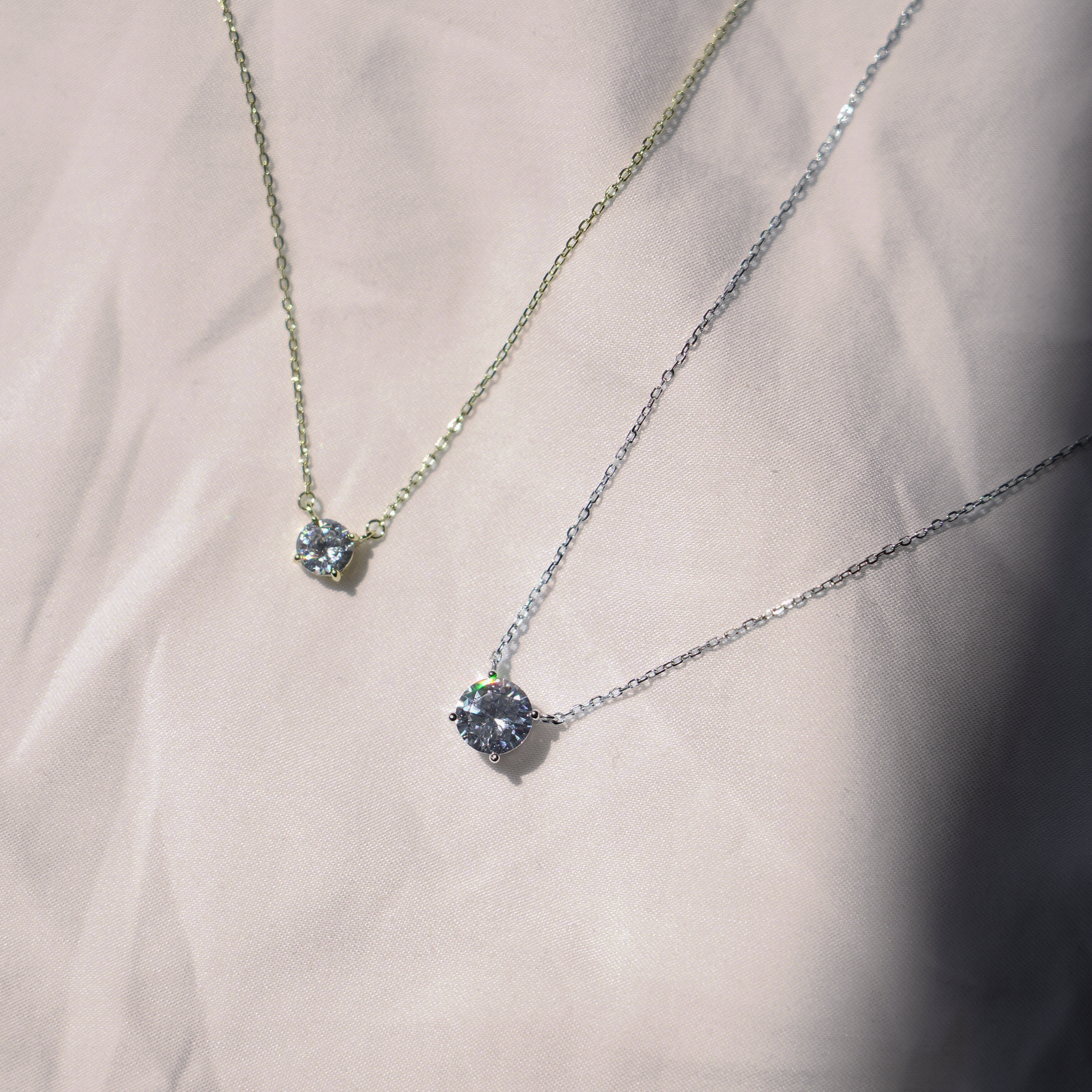 This necklace features a sparkling cubic zirconia set in a classic solitaire design. The pendant hangs on a delicate chain, available in gold vermeil or sterling silver. It closes with a secure spring ring clasp. The elegant design combines the warmth of gold and the shine of silver.