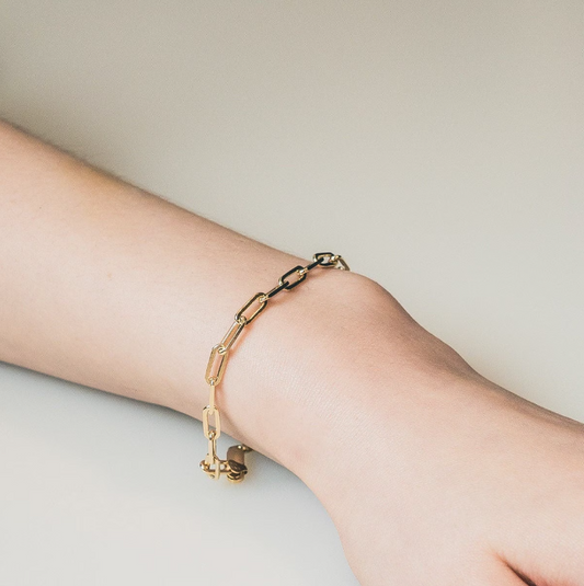 Delicate gold-toned bracelet with an interlinking chain-like pattern. The bracelet has a simple clasp closure, allowing for easy wear and removal. Made of a combination of sterling silver and a gold plating, creating a warm, lustrous finish.