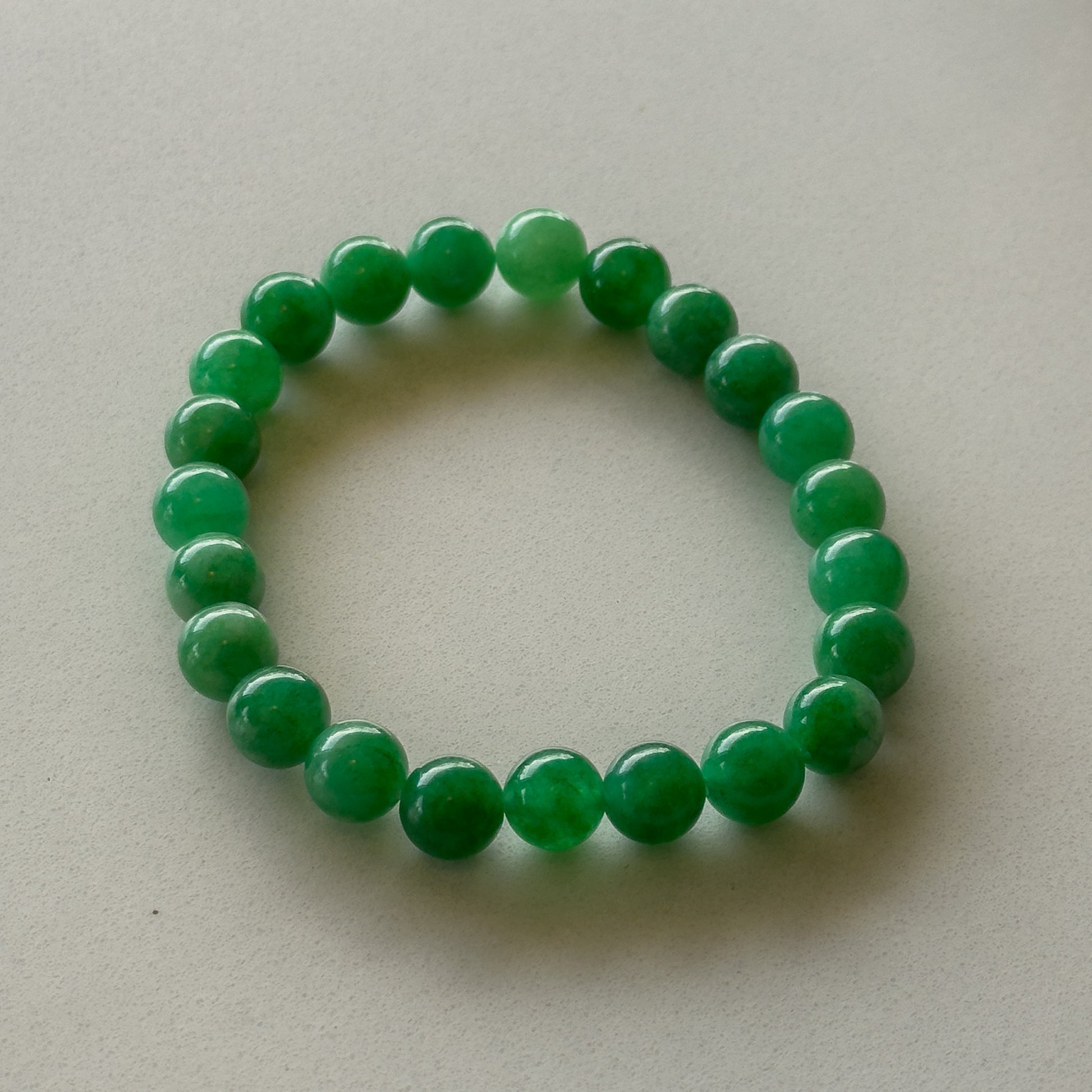 Simple pearl-shaped beaded bracelet made of vibrant green jade.