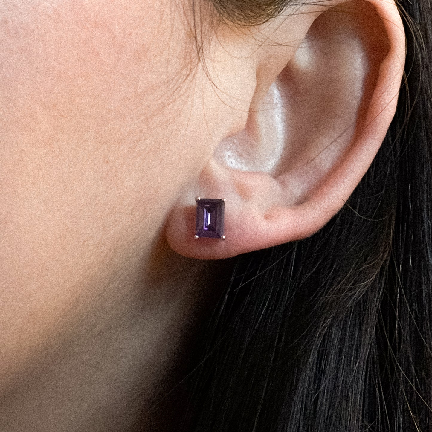 These stud earrings feature a rectangular, emerald-cut purple gemstone. The stone is set in a simple prong setting, made of 18k gold vermeil over 925 sterling silver. Standard push-back closure. Small and elegant, suitable for everyday wear.