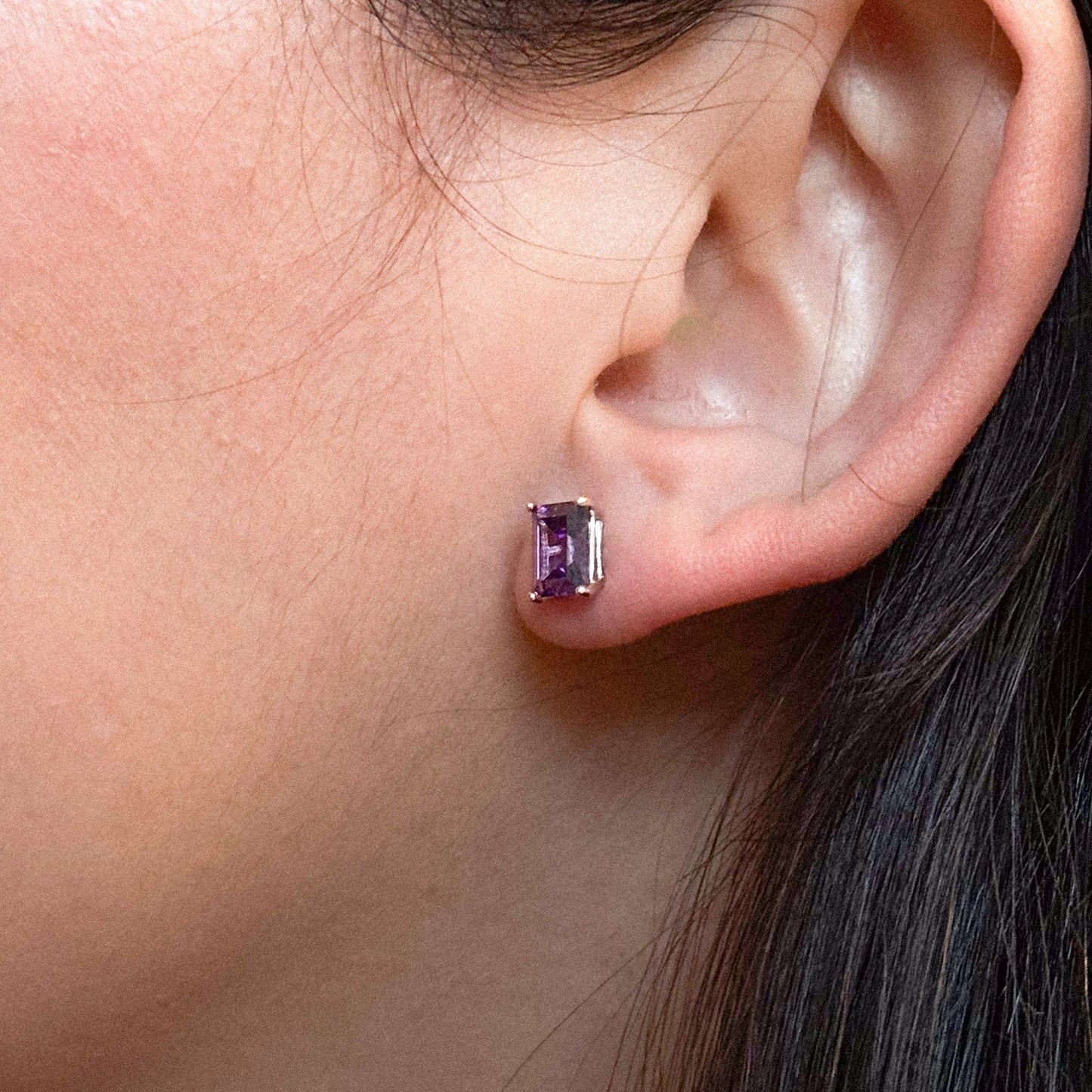 These stud earrings feature a rectangular, emerald-cut purple gemstone. The stone is set in a simple prong setting, made of 18k gold vermeil over 925 sterling silver. Standard push-back closure. Small and elegant, suitable for everyday wear.