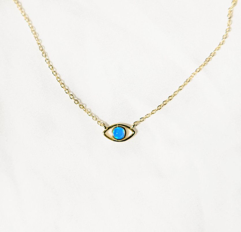 Gold vermeil chain with lobster clasp holds an evil eye charm. The eye is a round blue opal set in gold with a hanging gold vermeil chain below. Sterling silver and opal, gold-plated.