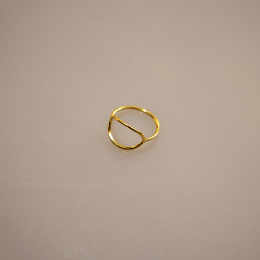 A simple, elegant gold vermeil ring forming a perfect circle, with a smooth, polished surface reflecting light softly. The slender band appears delicate yet sturdy, a timeless accessory suitable for any occasion.