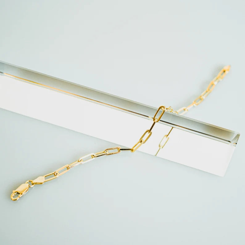 Delicate gold-toned bracelet with an interlinking chain-like pattern. The bracelet has a simple clasp closure, allowing for easy wear and removal. Made of a combination of sterling silver and a gold plating, creating a warm, lustrous finish.