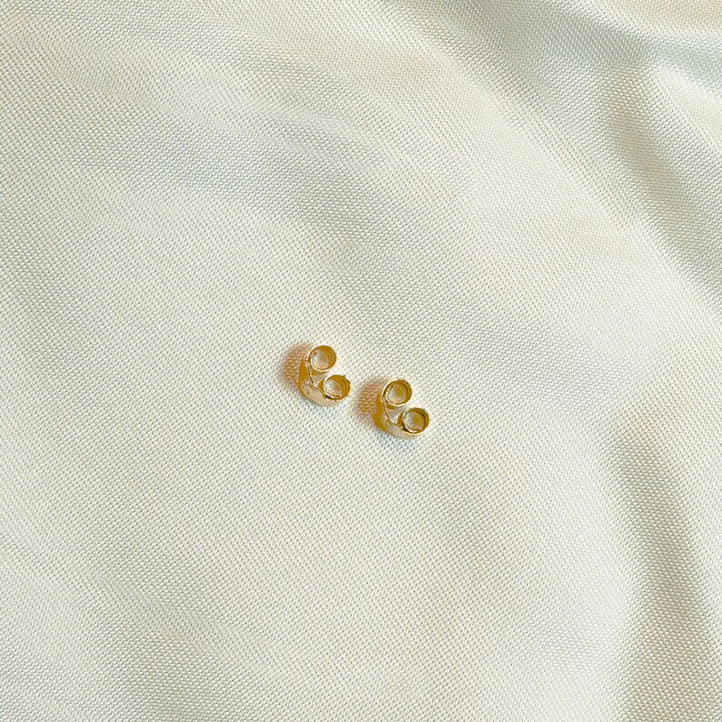 Gold ball stud earrings on thin post. Polished round beads, post and butterfly closure. 2mm diameter. Solid 14K gold, no plating or gemstones. Minimalist style.