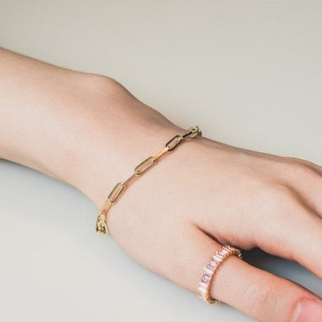 Delicate gold-toned bracelet with an interlinking chain-like pattern. The bracelet has a simple clasp closure, allowing for easy wear and removal. Made of a combination of sterling silver and a gold plating, creating a warm, lustrous finish.