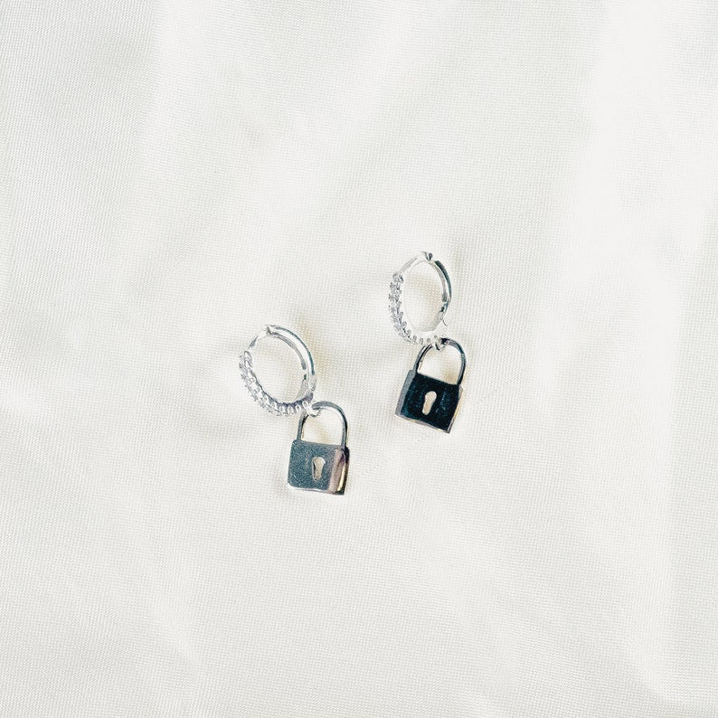 Designed with sensitive ears in mind, these hypoallergenic 925 sterling silver key lock hoop earrings feature sparkling cubic zirconia stones, ensuring a touch of glamour and comfort for all-day wear without any irritation or discomfort.