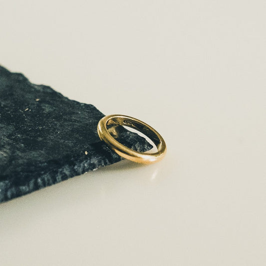 This ring features a classic band design in lustrous 18k gold vermeil. The smooth, polished surface reflects light beautifully, creating a simple yet elegant piece of jewelry suitable for everyday wear.